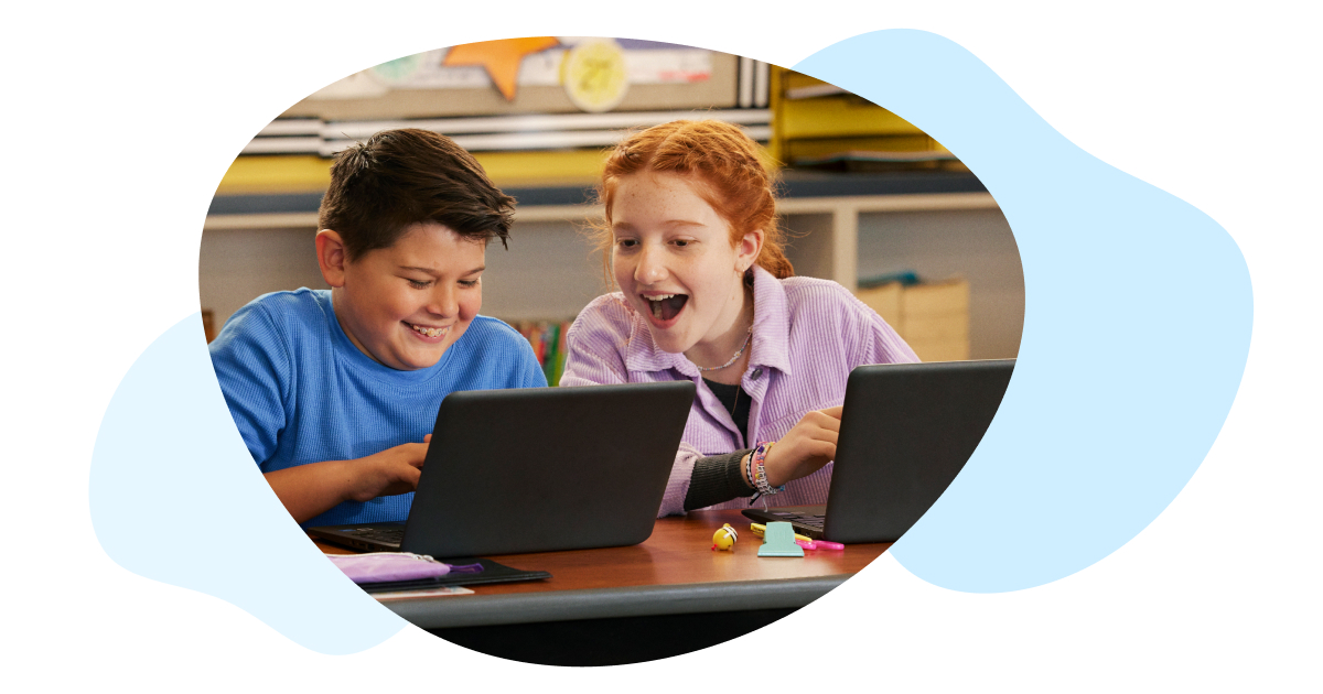 Two students look excitedly at laptops